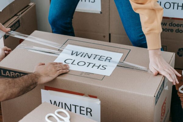Moving box clearly labelled Winter Clothes while being sealed