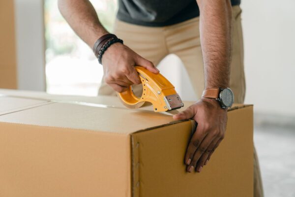 Sealing a cardboard box with packing tape before storage